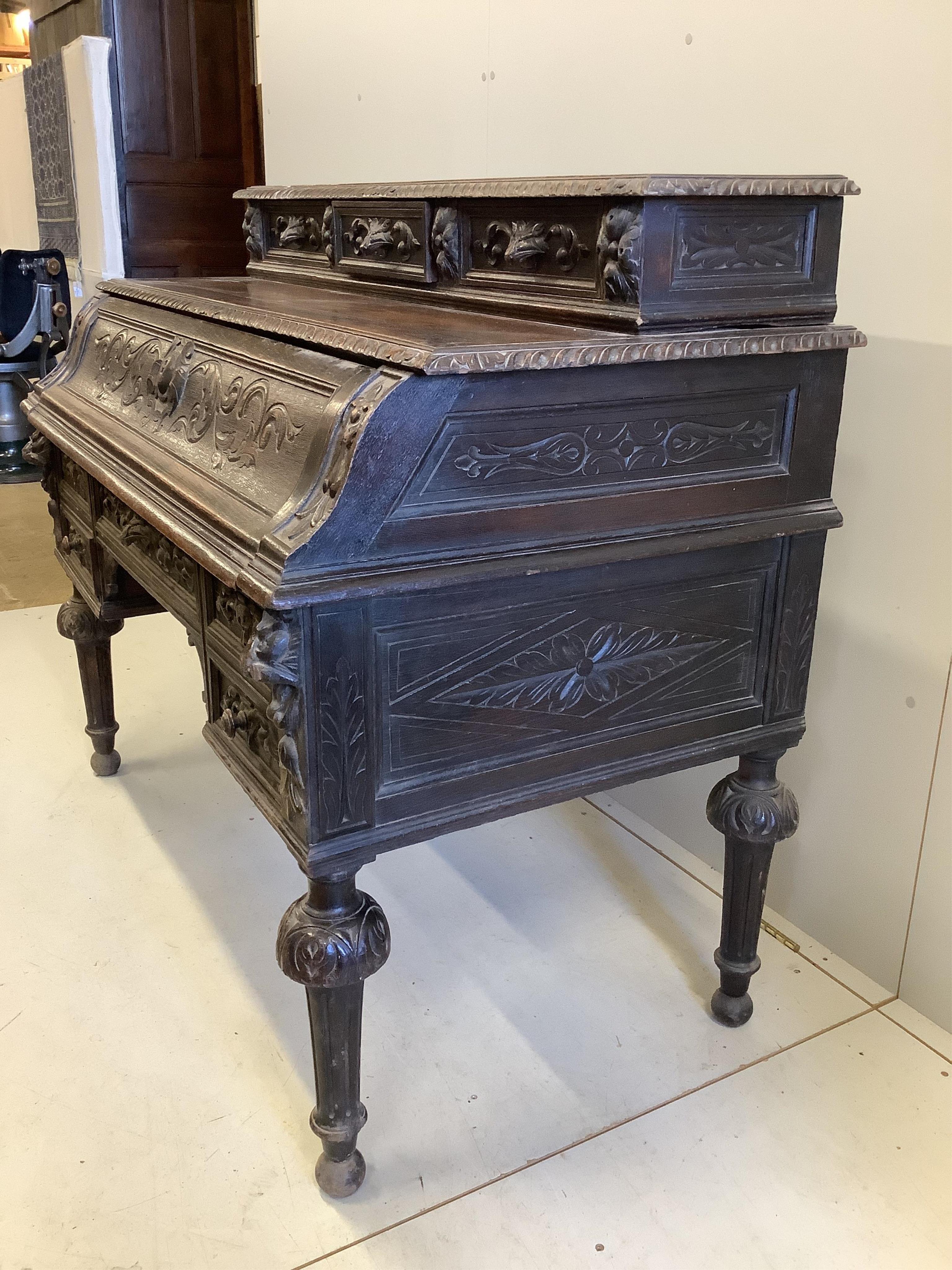 A late 19th century Flemish carved oak secretaire kneehole desk, width 129cm, depth 71cm, height 111cm. Condition - fair